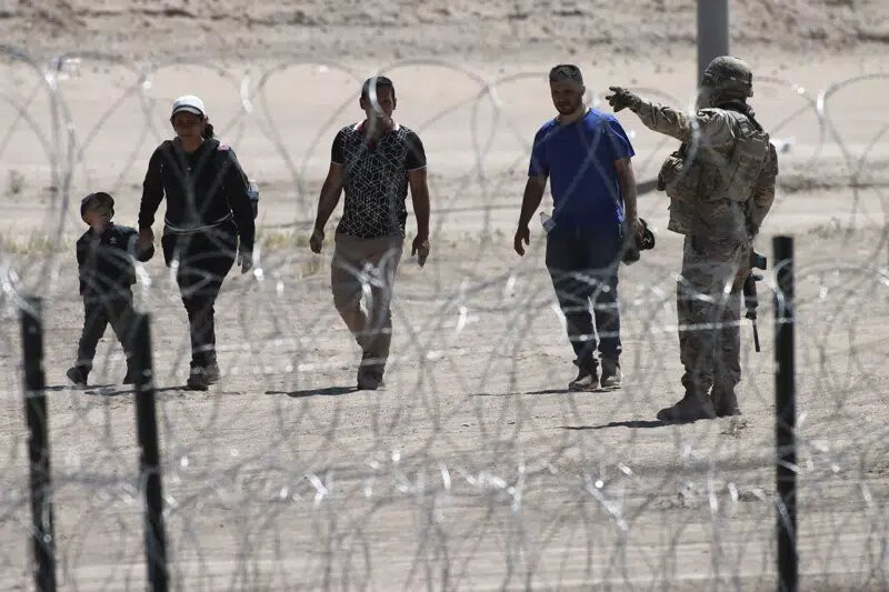 Migrantes esperan a las autoridades estadounidenses en la frontera entre EEUU y México, visto desde Ciudad Juárez, México, el miércoles 10 de mayo de 2023.