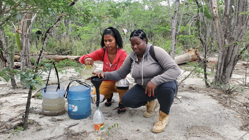 Roselina Cuevas y Alisia Guzmán, dos comunitarias, mojan las plantas