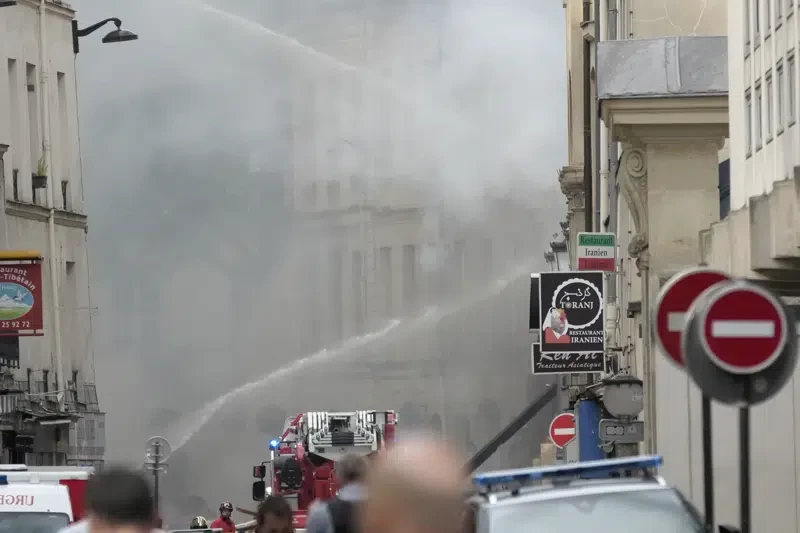 Bomberos combaten con un camión hidrante un incendio en la margen izquierda del Sena, París, miércoles 21 de junio de 2023. Vecinos dijeron a la prensa local que una fuerte explosión precedió el incendio y parte de un edificio se derrumbó.