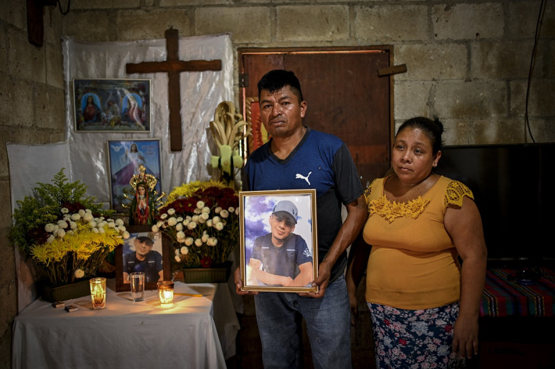 Manuel Rojche (izq.) y Rosario Chiquival (der.), padres del migrante guatemalteco Francisco Rojche, quien murió en un centro de detención de inmigrantes mexicano durante un incendio, posan con un retrato de su hijo durante una entrevista con AFP en Chicacao, Guatemala, el pasado junio.