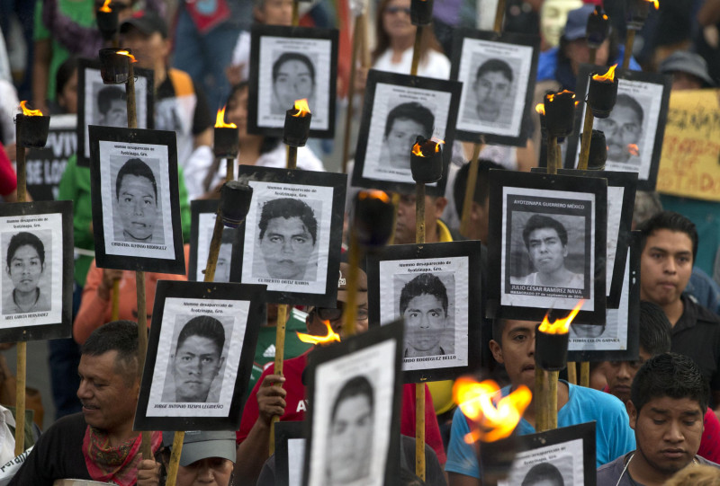 Familiares de 43 estudiantes universitarios de maestros desaparecidos llevan fotos de los estudiantes mientras marchan con simpatizantes para exigir que no se cierre el caso y que se sigan las recomendaciones de los expertos sobre nuevas pistas, en la Ciudad de México, el martes 26 de abril de 2016.