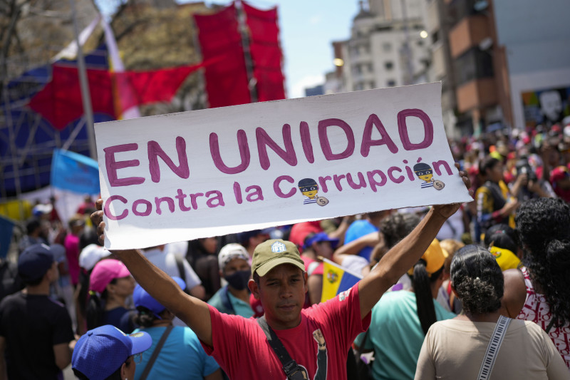 Un simpatizante gubernamental sostiene un letrero durante una marcha contra la corrupción, el sábado 25 de marzo de 2023, en Caracas, Venezuela.