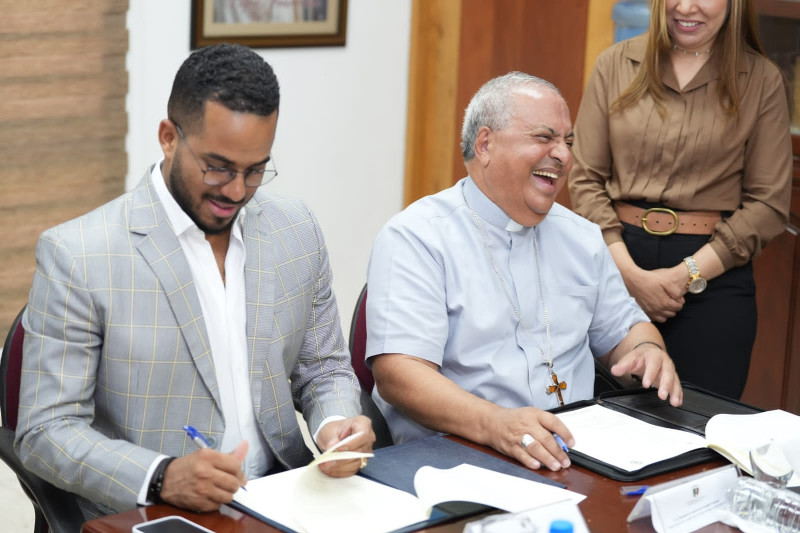 Ministro de la Juventud Feliz García y rector de la Universidad Católica de Santo Domingo (UCSD) mientras firman acuerdo