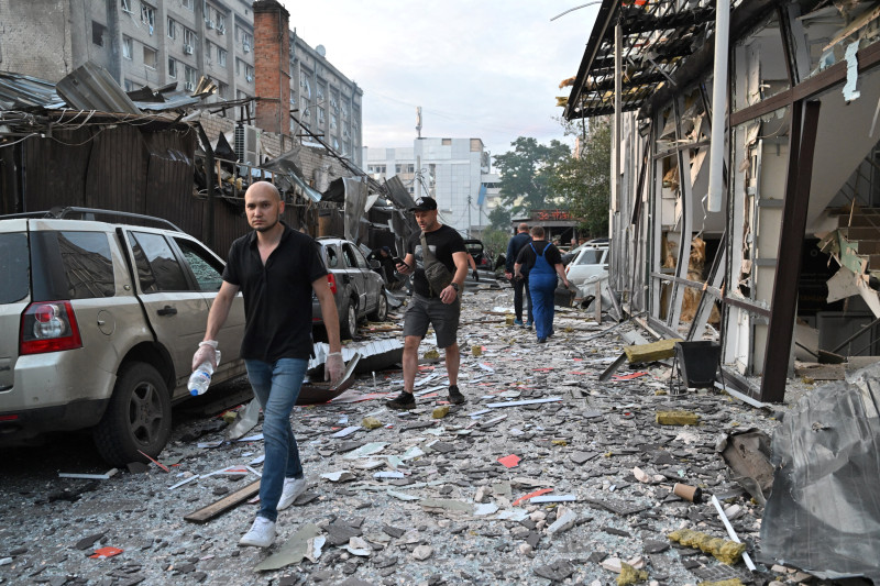 Varias personas pasan frente a un restaurante en Kramatorsk, en el este de Ucrania, después de que un misil lo impactara el 27 de junio de 2023.