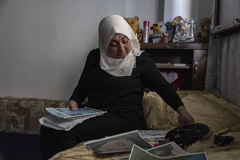 Hamrin Alouji, madre de Peyal Aqil, de 13 años, revisa las fotos de su hija en su casa en Qamishli, Siria, el 5 de junio de 2023.