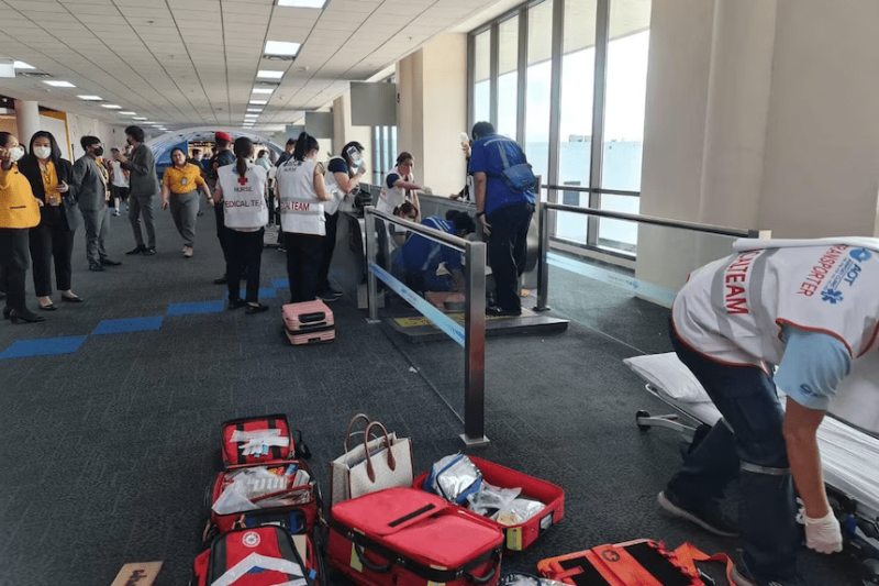 Equipo médico y personal del aeropuerto asisten a mujer accidentada.