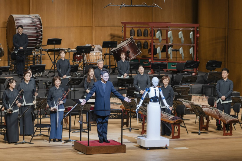 Esta foto tomada el 30 de junio de 2023 y facilitada por el Teatro Nacional de Corea muestra al robot surcoreano "EveR 6" (dcha.) dirigiendo a los músicos de la Orquesta Nacional de Corea en colaboración con un maestro humano (izq.) durante un concierto en el Teatro Nacional de Seúl.