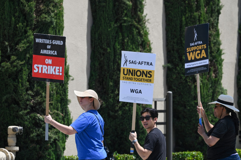 Los escritores de Hollywood y sus partidarios del sindicato de actores SAG AFTRA caminan en la línea de piquete frente a los estudios Warner Bros en Burbank, California, el 30 de junio de 2023