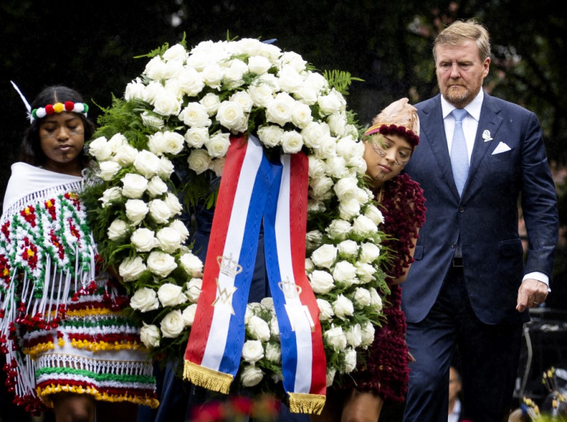 El rey Willem-Alexander (derecha) de los Países Bajos coloca una ofrenda floral durante el Día Nacional de Conmemoración de la Esclavitud en el Oosterpark, Ámsterdam, el 1 de julio de 2023.