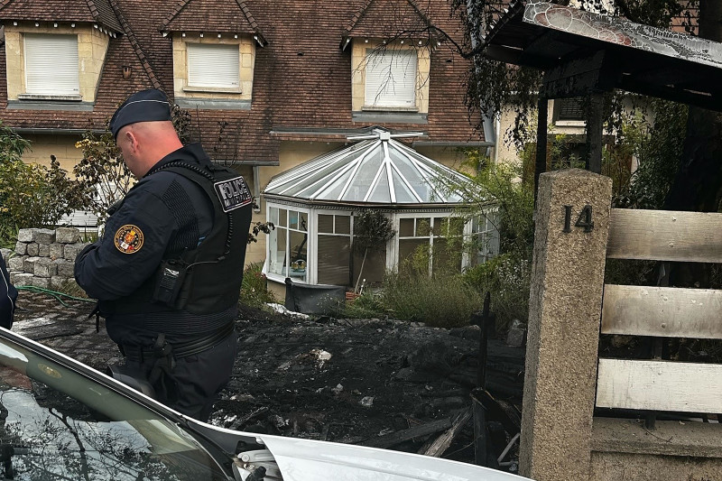 Un oficial de policía municipal se para frente a la casa dañada del alcalde de l'Hay-les-Roses, Vincent Jeanbrun, en l'Hay-les-Roses, un suburbio de París, el 2 de julio de 2023, después de que los alborotadores embistieran un vehículo