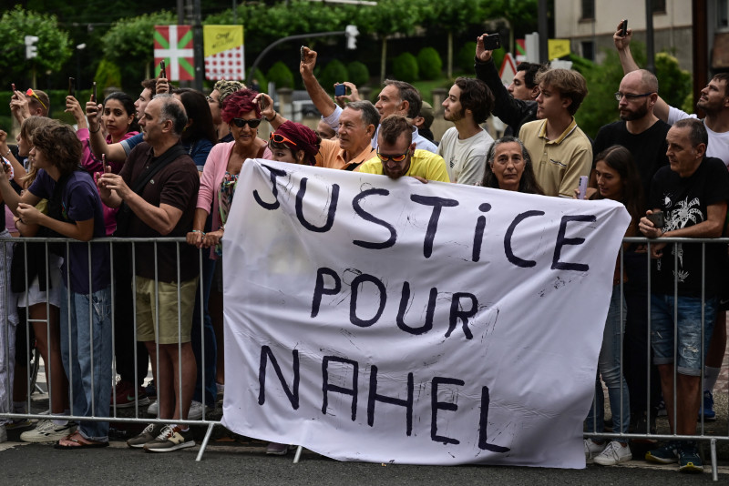 Los espectadores despliegan una pancarta que dice "Justicia para Nahel" a lo largo de la ruta de la carrera al comienzo de la 1.ª etapa de la 110.ª edición del Tour de Francia, 182 km con salida y llegada en Bilbao, en el norte de España, el 1 de julio. 2023.