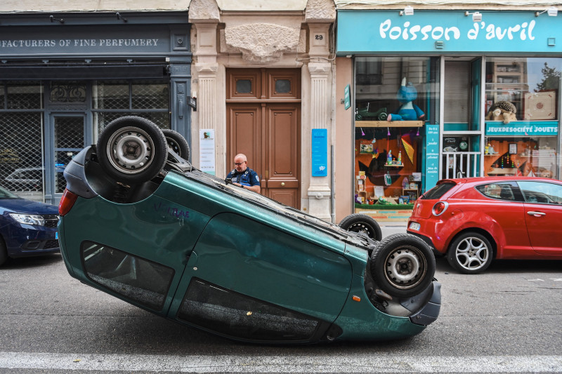 Un automóvil que está boca abajo en una calle luego de una cuarta noche consecutiva de disturbios en Francia provocados por la muerte del conductor adolescente Nahel por una bala de la policía, en Lyon, sureste de Francia.