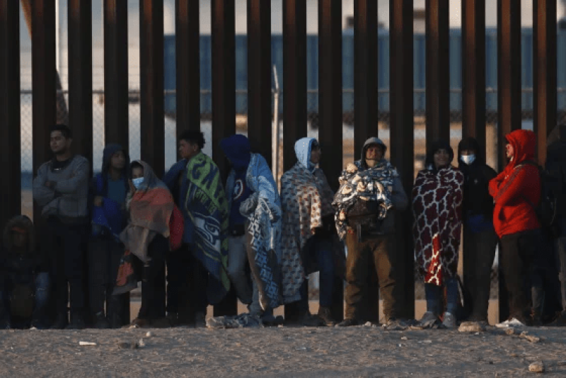 Migrantes se reúnen junto al muro fronterizo en Ciudad Juárez, México, el miércoles 21 de diciembre de 2022, al otro lado de la frontera con El Paso, Texas. Los migrantes se reunieron a lo largo del lado mexicano de la frontera sur el miércoles mientras esperaban que la Corte Suprema de los Estados Unidos decidiera si levantar las restricciones de la era de la pandemia que han impedido que muchos busquen asilo y cuándo.
