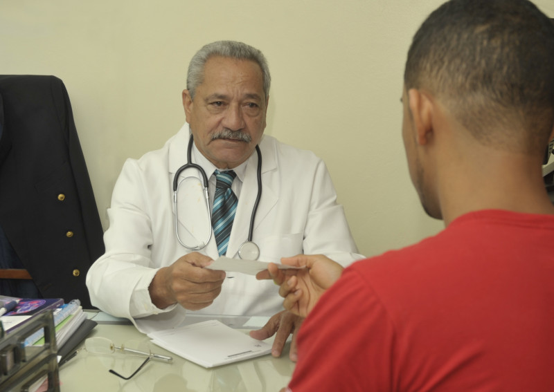 Doctor José Agustín Sehuoerer Luna recibe paciente en consultorio del Listín Diario.