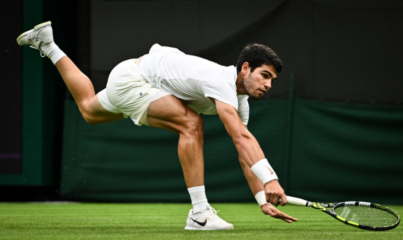 Carlos Alcaraz salta por la pelota ante el francés Jeremy Chardy durante su partido de tenis individual masculino en el segundo día de los Campeonatos de Wimbledon 2023