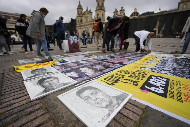 Manifestantes colocan fotos de supuestos falsos positivos, durante un homenaje a ellos en Bogota, el 30 de agosto de 2021.