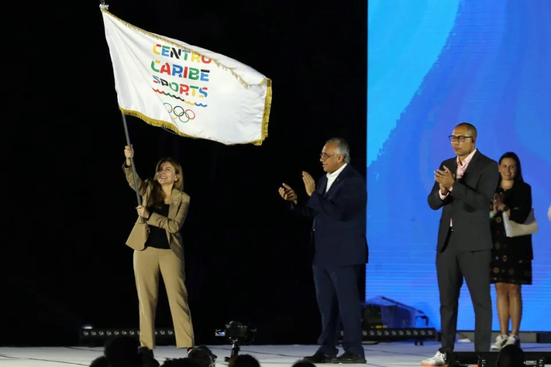 Carolina Mejía, alcaldesa de Santo Domingo, ondea la bandera de Centro Caribe Sports en la ceremonia de clausura.