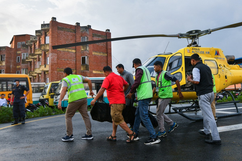 Las personas llevan el cuerpo de la víctima que murió en un accidente de helicóptero, en el Hospital Docente de la Universidad de Tribhuvan en Katmandú el 11 de julio de 2023. Las seis personas a bordo de un helicóptero turístico en Nepal murieron cuando se estrelló poco después del despegue en la región del Everest el 11 de julio de 2023.