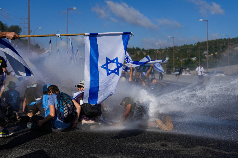 La policía israelí utiliza un cañón de agua para dispersar a los manifestantes que bloqueaban una autopista a Jerusalén, durante protestas contra los planes de reforma judicial del gobierno del primer ministro, Benjamin Netanyahu,  ayer.
