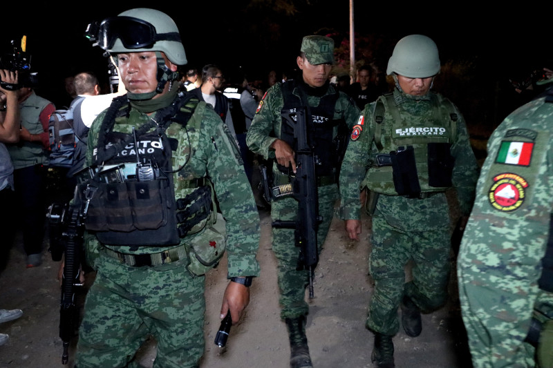 Personal del Ejército, fiscales de Jalisco y peritos forenses recolectan pruebas tras un atentado con explosivos contra policías y personal de la procuraduría estatal, en Tlajomulco