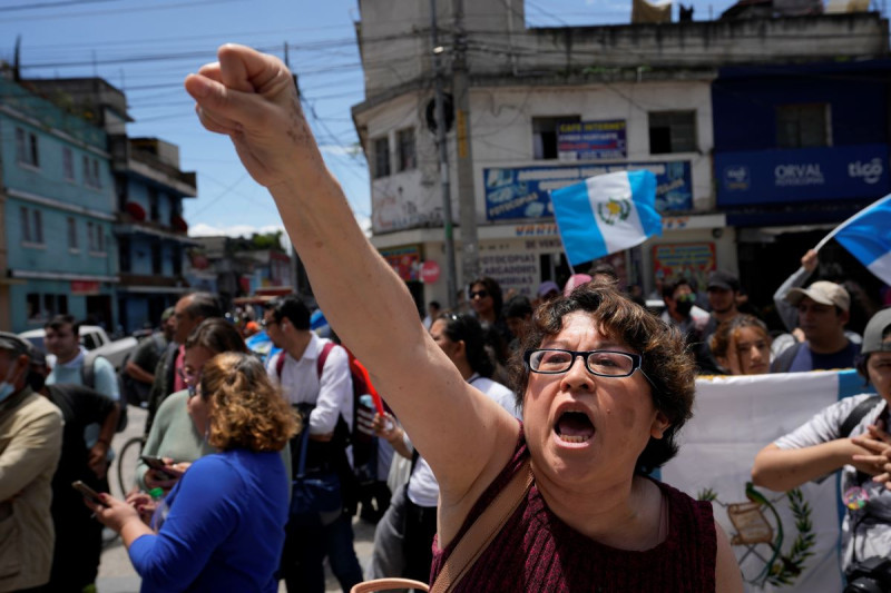 Manifestantes se reúnen el jueves 13 de julio de 2023 frente a la fiscalía general en la Ciudad de Guatemala para protestar porque allanó la sede de la autoridad electoral.
