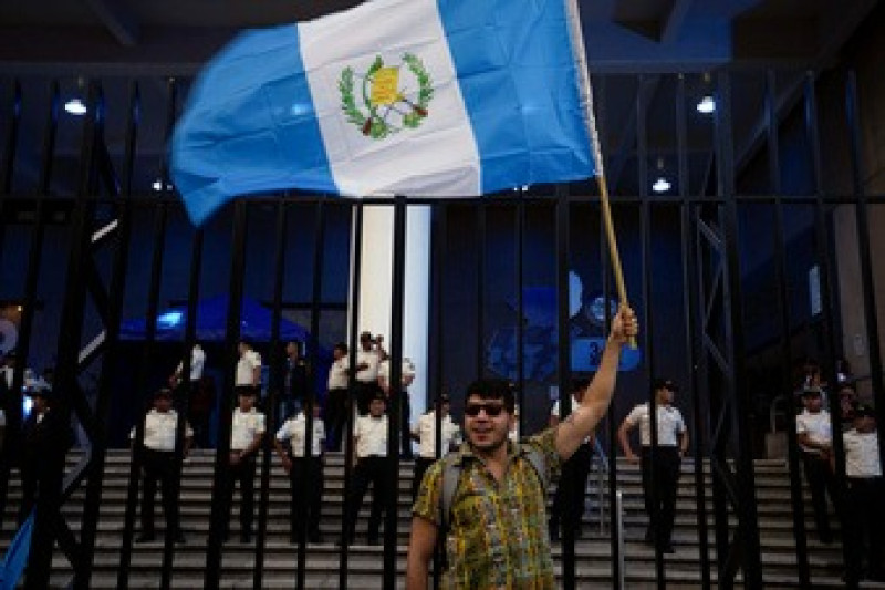 Un manifestante ondea una bandera guatemalteca frente al edificio de la oficina del Fiscal General ayer.