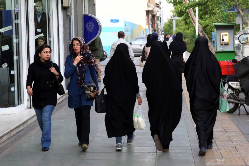 Mujeres iraníes caminan por una vereda en el centro de Teherán, Irán, el martes 26 de abril de 2016.