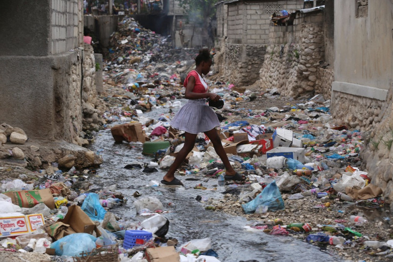 Una niña camina por una calle llena de basura en Puerto Príncipe, Haití, el jueves 13 de julio de 2023.