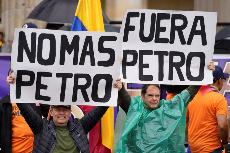 Militares retirados llevan carteles de rechazo a Gustavo Petro en protesta por reformas iniciadas por su gobierno en la plaza de Bolívar de Bogotá, ayer.