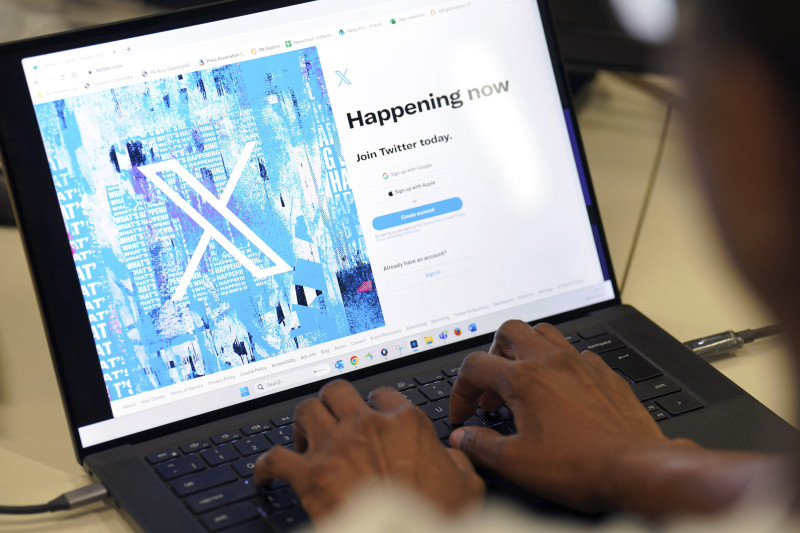 Una persona posa para una foto mientras se registra en Twitter, en una pantalla que muestra el nuevo logotipo de la plataforma, en una oficina en el centro de Londres, el lunes 24 de julio de 2023.