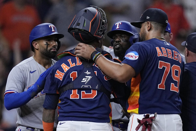 El puertorriqueño Martín Maldonado, de los Astros de Houston, y el cubano Adolis García (derecha), de los Rangers de Texas, discuten en el juego del miércoles.