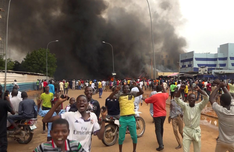 Con la sede del gobierno ardiendo de fondo, partidarios de los soldados amotinados se manifiestan en Niamey, antier.