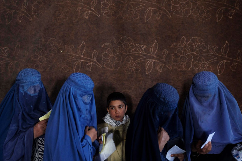 Mujeres afganas esperan para recibir dinero en efectivo en un punto de distribución de ayuda organizado por el Programa Mundial de Alimentos, en Kabul, Afganistán, el 20 de noviembre de 2021.