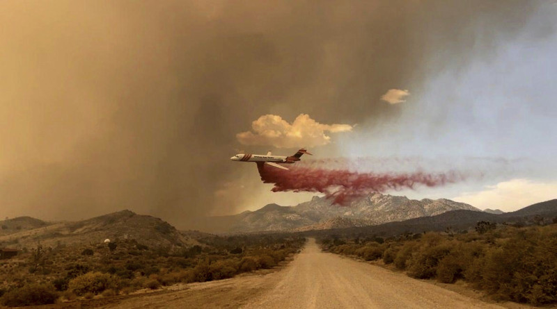Esta fotografía difundida por la Reserva Nacional de Mojave del Servicio de Parques Nacionales muestra un avión cisterna dejando caer retardante contra fuego sobre un incendio, el sábado 29 de julio de 2023, en la Reserva Nacional de Mojave.