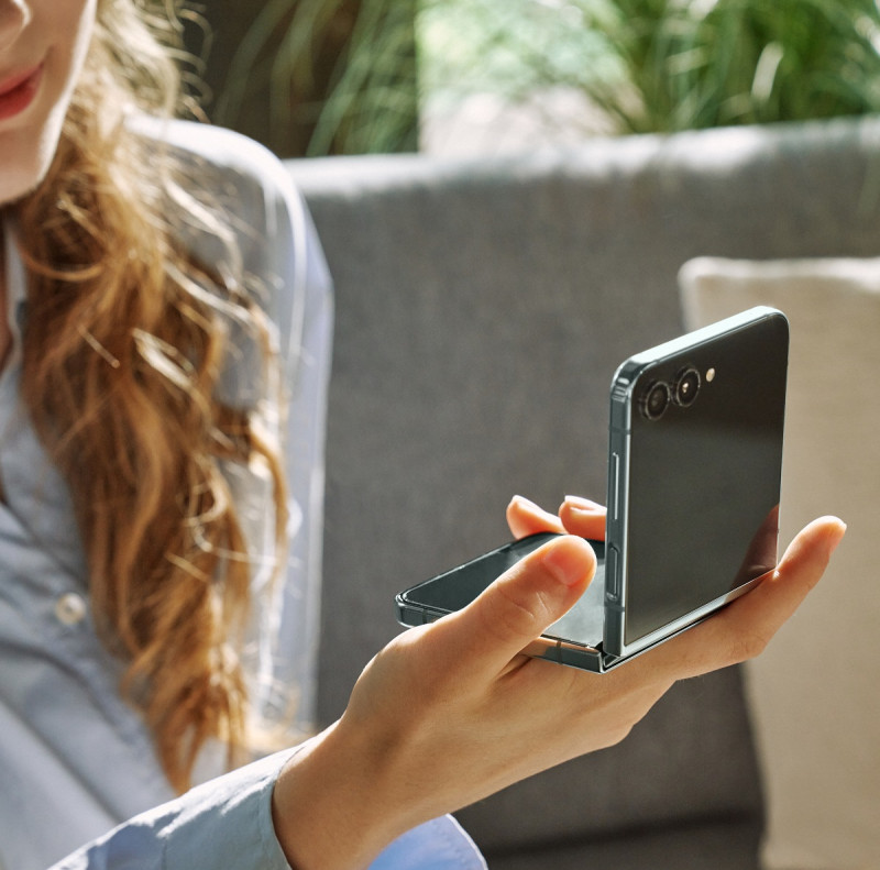 La industria hace esfuerzos por emplear cada vez más materiales reciclados en la fabricación de sus productos. Una mujer usa un celular Galaxy Z Flip5.