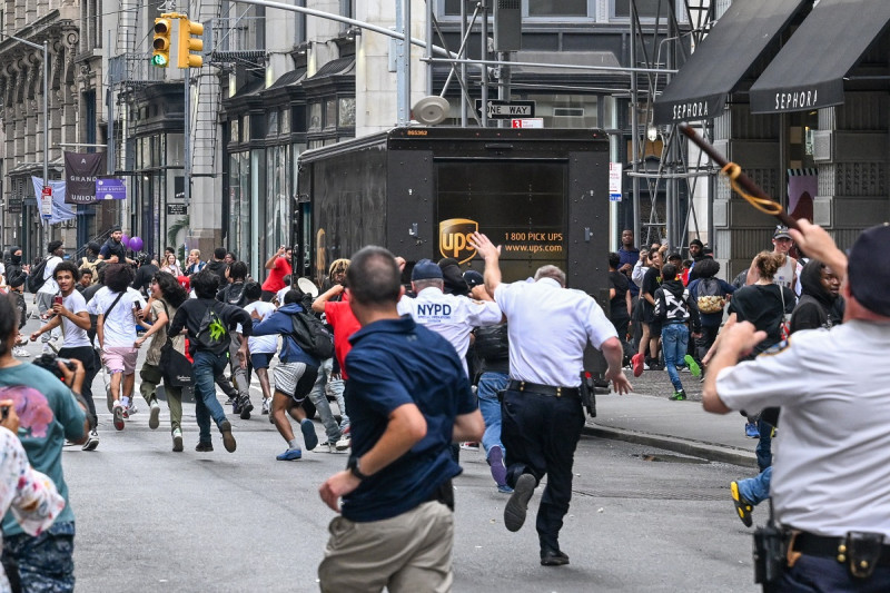 Se lanzan placas cerca de Chelsea mientras los miembros de la policía de Nueva York responden a las interrupciones causadas por grandes multitudes durante un evento de "regalo" organizado por el popular transmisor en vivo de Twitch Kai Cenat en Union Square y sus alrededores en agosto 4, 2023 en la ciudad de Nueva York.