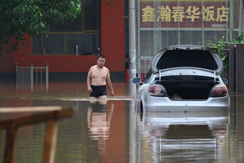 Un hombre camina por un camino inundado luego de fuertes lluvias en Zhuozhou, en la provincia de Hebei, en el norte de China, el 2 de agosto de 2023. Las lluvias mortales que azotaron la capital de China en los últimos días fueron las más intensas desde que comenzaron los registros hace 140 años, dijo el servicio meteorológico de Beijing el 2 de agosto de 2023.