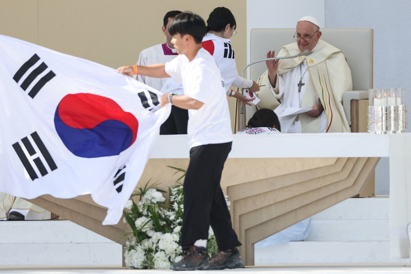 El Papa Francisco hace un gesto mientras los peregrinos celebran en el escenario con una bandera de Corea del Sur, ya que la próxima JMJ se llevará a cabo en Seúl, durante la misa de clausura de las Jornadas Mundiales de la Juventud (JMJ) en el Parque Tajo, Lisboa, el 6 de agosto de 2023.