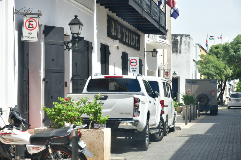 Vehículos estacionados en zona de grúa incumpliendo la señal reglamentaria de "no estacione" en la Ciudad Colonial.