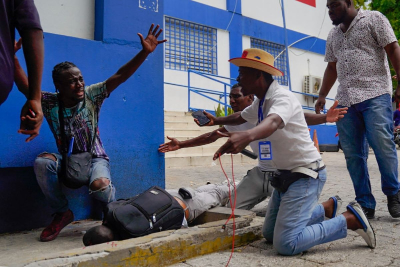 Periodistas lloran y piden ayuda cerca del cuerpo de Romelo Vilsaint, quien fue alcanzado por una bomba lacrimógena cuando se reunían en la comisaría de Delmas 33 exigiendo la liberación de su colega Robest Dimanche, quien fue detenido mientras cubría una protesta , en Port-au-Prince, Haití, el 30 de octubre de 2022. -