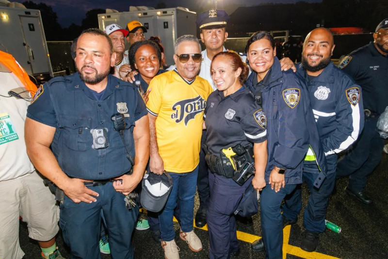 Héctor Acosta "El Torito", al centro, mientras posa con policías previo a un concierto en Nueva York.