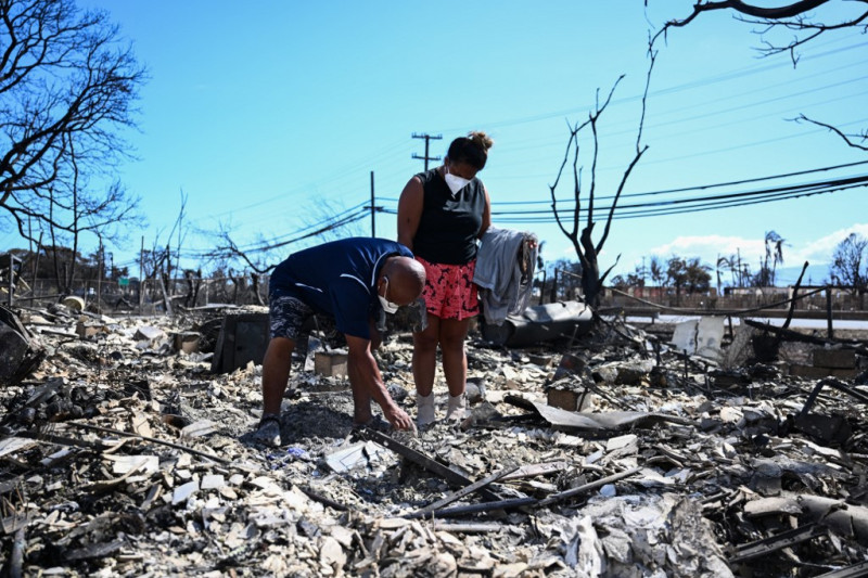 Davilynn Severson y Hano Ganer buscan pertenencias entre las cenizas de la casa de su familia después de un incendio forestal en Lahaina, en el oeste de Maui, Hawái, el 11 de agosto de 2023. Un incendio forestal que dejó a Lahaina en ruinas carbonizadas ha matado al menos a 80 personas.