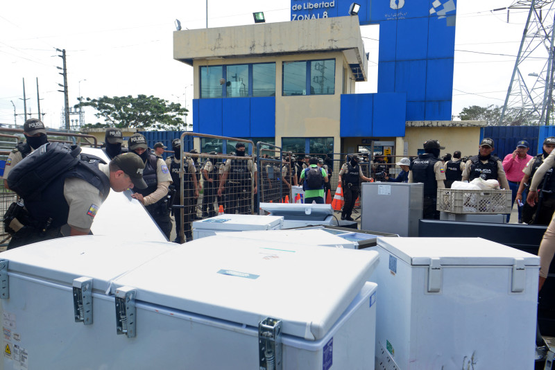 Agentes de policía recogen congeladores confiscados, entre otros materiales, durante una operación conjunta entre la Policía y las Fuerzas Armadas.
