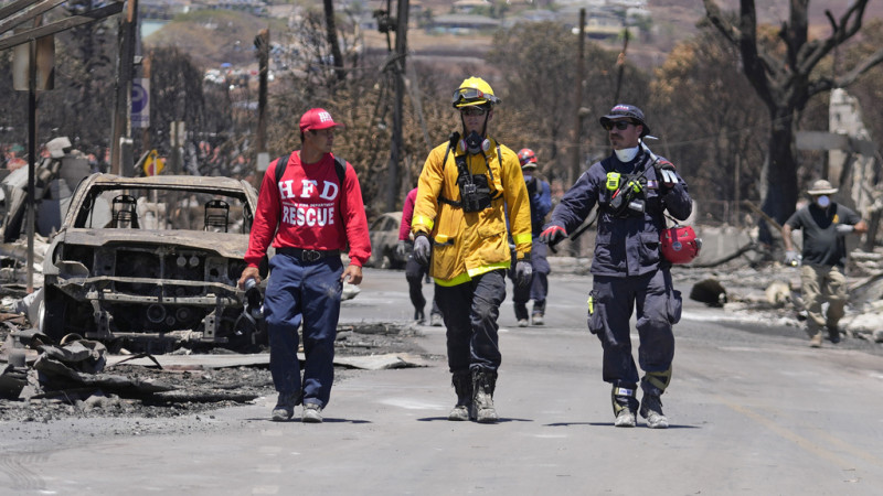Miembros del equipo de búsqueda y rescate caminan por una calle el sábado 12 de agosto de 2023 en Lahaina, Hawai, tras un incendio que provocó graves daños.