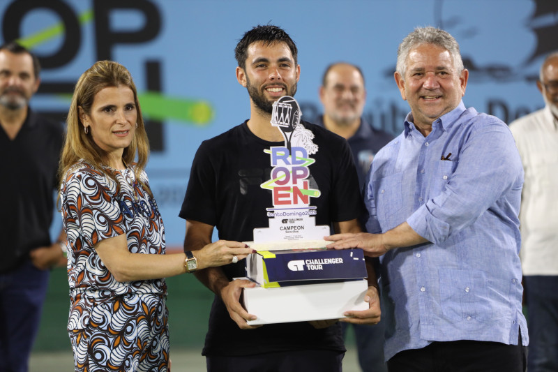 Genaro Olivieri recibe su trofeo como campeón del RD Open 2023 de manos de Ligia Bonetti y Roberto Henríquez.