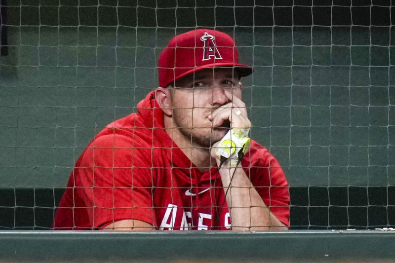 Mike Trout de Los Angelinos de Los Ángeles observa desde el banco durante la novena entrada del juego ante los Astros de Houston.