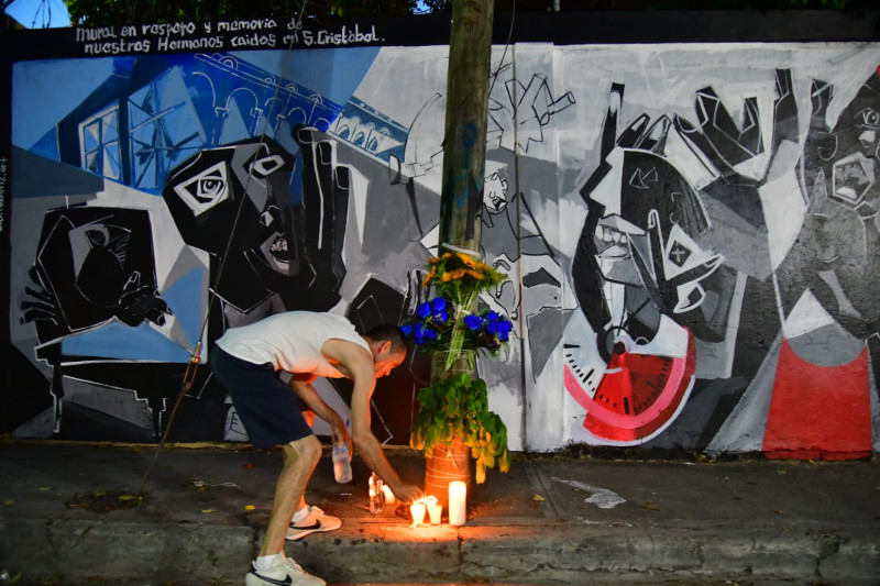 Hombre encendiendo velas en la calle Jesús de Galíndez, en memoria de los fallecidos.