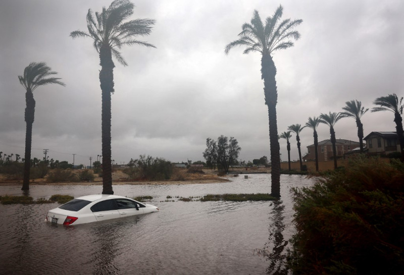 Un automóvil está parcialmente sumergido en las aguas de la inundación mientras la tormenta tropical Hilary
