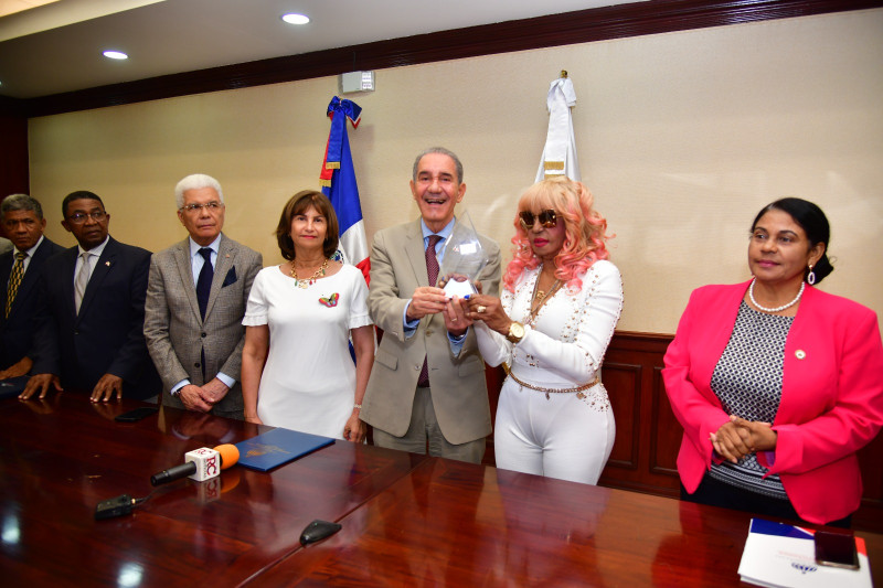Fefita La Grande recibiendo reconocimiento de la mano del ministro del Mescyt, Franklin García Fermín