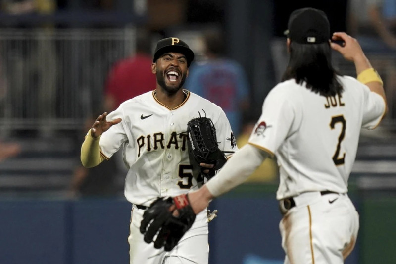 El jardinero de los Piratas celebra con Connor Joe tras capturar una bola que bateó José Fermín de los Cardenales de San Luis en la novena entrada del encuentro.